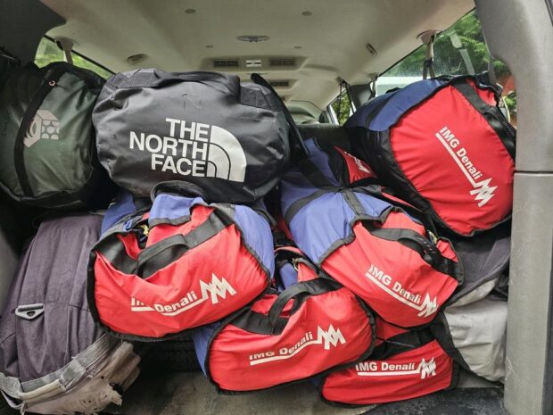 A pile of duffles in the back of the IMG van, waiting to head to the airtport