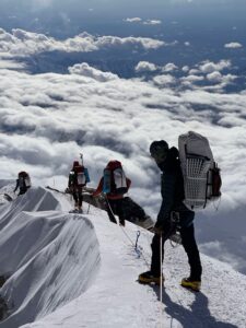 A team walks along a ridge up to the Summit of Denali